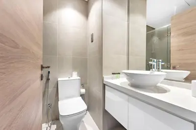 a bathroom with a white toilet and a sink at StoneTree - Studio One Tower Studio - Amazing View and Facilities in Dubai