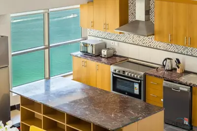 a kitchen with a counter and a large window at Ain Dubai & Sea Views 2BR Close to Beach, Rimal 4, Jumeirah Beach Residence, by Deluxe Holiday Homes in Dubai