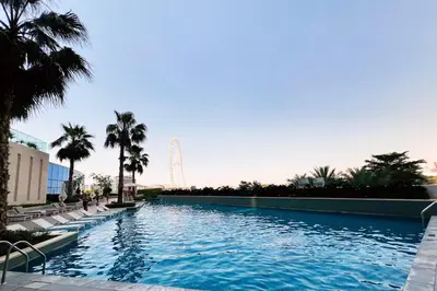 a swimming pool with palm trees and a ferris wheel at Address JBR Marina Views, Address Beach Resort Residence, Dubai Marina - Mint Stay in Dubai