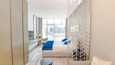 a hotel room with a bed and a large window at Sleek Studio in Business Bay with Canal View Business Bay, Dubai in Dubai