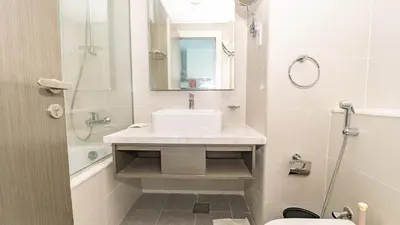 a bathroom with a sink and a toilet and a mirror at Sleek Studio in Business Bay with Canal View Business Bay, Dubai in Dubai