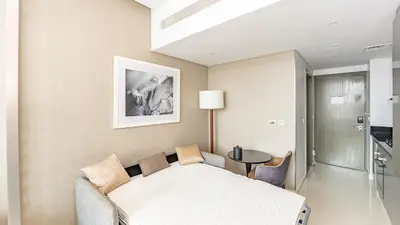 a bedroom with a bed and a table in a room at Sleek Studio in Business Bay with Canal View Business Bay, Dubai in Dubai