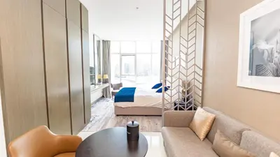 a living room with a couch and a bed at Sleek Studio in Business Bay with Canal View Business Bay, Dubai in Dubai