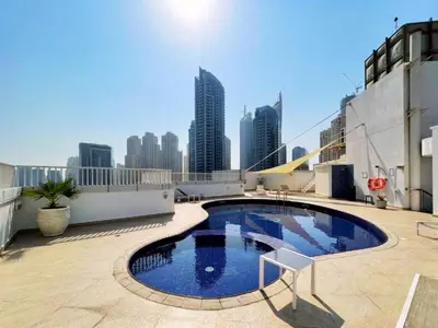 a swimming pool on the roof of a building with a city skyline at Charming 2BR + kid's room w/ Marina yacht view in Dubai