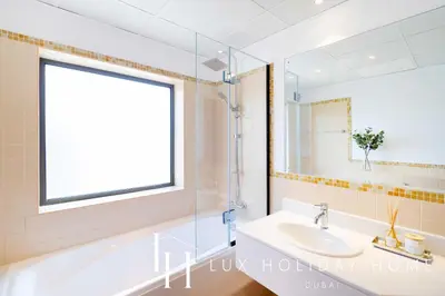 a bathroom with a sink and a tub and a mirror at LUX The JBR Marina View Suite 2 in Dubai