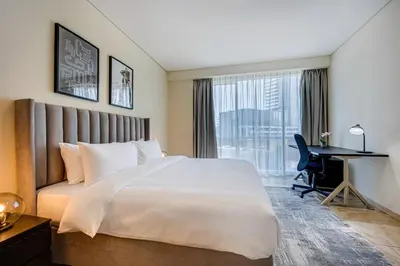 a hotel room with a large bed and a desk at Huge fantastic 3 bedroom in Al Fattan Marine Tower in Dubai