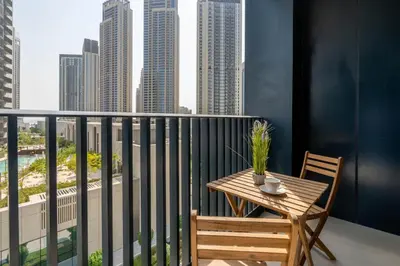 a table and chairs on a balcony with a view of a city at GuestReady - A prime stay in Creek Harbour in Dubai