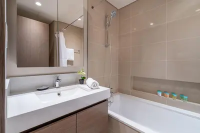 a bathroom with a white sink and a bath tub at GuestReady - A prime stay in Creek Harbour in Dubai