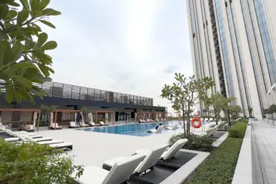 a swimming pool with white lounge chairs next to a building at GuestReady - A prime stay in Creek Harbour in Dubai