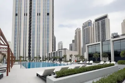 a view of a pool with chairs and buildings at GuestReady - A prime stay in Creek Harbour in Dubai