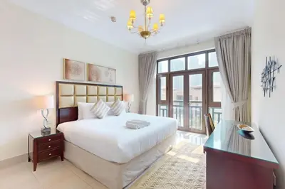 a bedroom with a white bed and a glass table at Souq Al Bahar - One Bed with Dubai Fountain View in Dubai