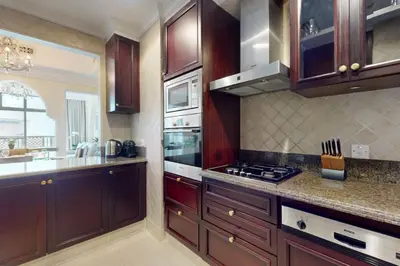 a kitchen with wooden cabinets and a stove top oven at Souq Al Bahar - One Bed with Dubai Fountain View in Dubai