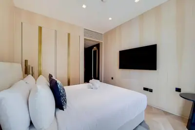a bedroom with a white bed with pillows and a tv at FIVE Palm North Residences - Spectacular Three Bedroom in Dubai