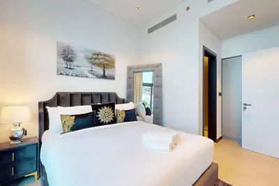 a bedroom with a large white bed and a table at 15 Northside Tower 2 - Spacious One Bedroom in Dubai