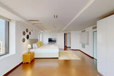 a white bedroom with a bed and a table at Bahar 1 - Opulent Three Bedroom in Dubai
