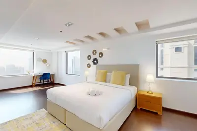 a white bedroom with a large white bed and windows at Bahar 1 - Opulent Three Bedroom in Dubai