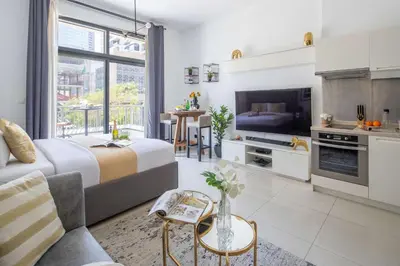 a living room with a bed and a kitchen at Frank Porter - Claren Tower in Dubai