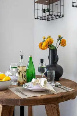 a wooden table with a plate and a vase with flowers at Frank Porter - Claren Tower in Dubai