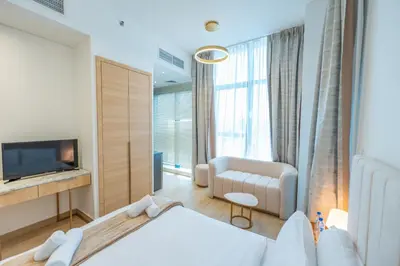 a bedroom with a bed and a chair and a television at Cozy Circle !Enjoyable Yet Affordable Studio Apartment! in Dubai