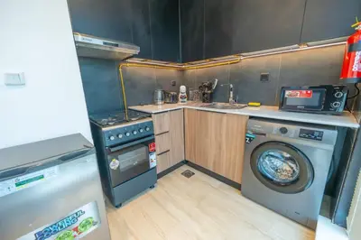 a kitchen with a washing machine and a washer at Cozy Circle !Enjoyable Yet Affordable Studio Apartment! in Dubai