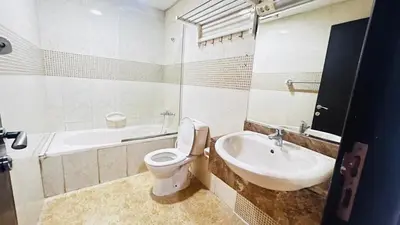 a white bathroom with a toilet and a sink at Beautiful Partition Room in Al barsha 1 Near Metro in Dubai