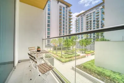 a balcony with a table and chairs on it at Luxury Studio in Sobha Hartland Greens by PK Holidays in Dubai