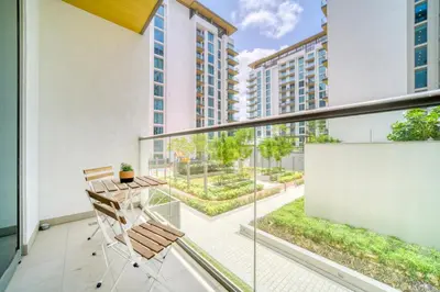 a balcony with a table and chairs on a building at Luxury Studio in Sobha Hartland Greens by PK Holidays in Dubai