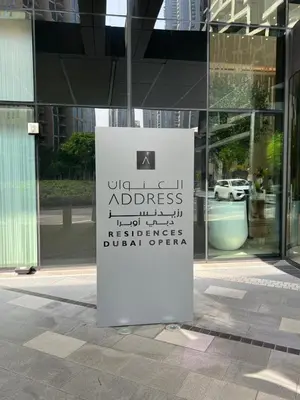 a sign in front of a glass building at Hotel Apartment Near Burj Khalifa - Opera T2 - شقة فندقية قريبة من برج خليفة اوبرا -برج 2 in Dubai