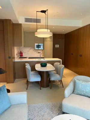 a living room with a table and chairs and a kitchen at Hotel Apartment Near Burj Khalifa - Opera T2 - شقة فندقية قريبة من برج خليفة اوبرا -برج 2 in Dubai