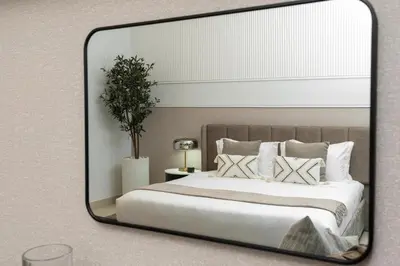 a mirror in a bedroom with a bed and pillows at Ultimate Stay Full Burj Khalifa & Downtown Views Designer Luxury High Floor connected to Dubai Mall for 4 People in Dubai