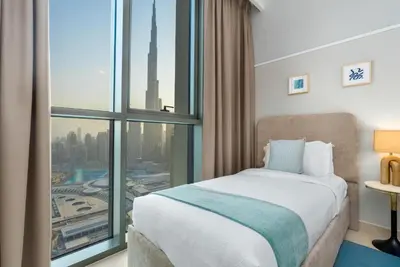a hotel room with a bed and a large window at Ultimate Stay Full Burj Khalifa & Downtown Views Designer Luxury High Floor connected to Dubai Mall for 4 People in Dubai