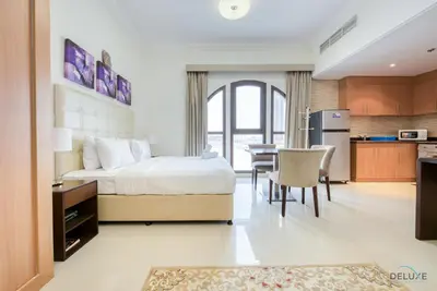 a bedroom with a bed and a kitchen with a table at Near to Iconic Miracle & Butterfly Garden Urban Vibe Studio, Lincoln Park A, Arjan-Dubailand by Deluxe Holiday Homes in Dubai