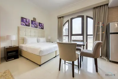 a bedroom with a bed and a table and chairs at Near to Iconic Miracle & Butterfly Garden Urban Vibe Studio, Lincoln Park A, Arjan-Dubailand by Deluxe Holiday Homes in Dubai