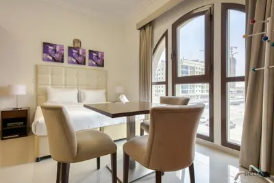 a bedroom with a bed and a table and chairs at Near to Iconic Miracle & Butterfly Garden Urban Vibe Studio, Lincoln Park A, Arjan-Dubailand by Deluxe Holiday Homes in Dubai