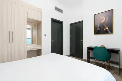 a bedroom with a bed and a desk and a chair at The Elite Apartment in Dubai