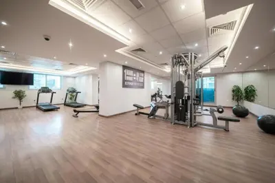 a gym with exercise equipment in a large room at The Elite Apartment in Dubai