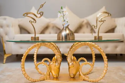 a coffee table with a gold pretzel legs and a glass top at Elite Royal Apartment - Full Burj Khalifa & Fountain View - Luxurious - Largest Layout - Melchior in Dubai
