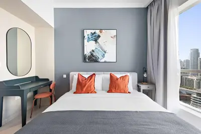 a bedroom with a bed and a desk and a window at Silkhaus in Bay Central Near Metro in Dubai