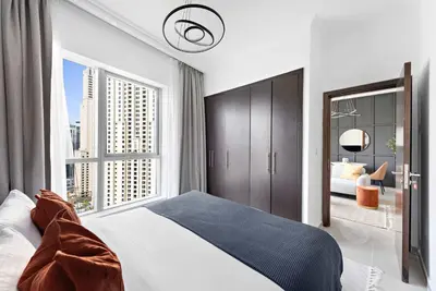 a bedroom with a bed and a large window at Silkhaus in Bay Central Near Metro in Dubai