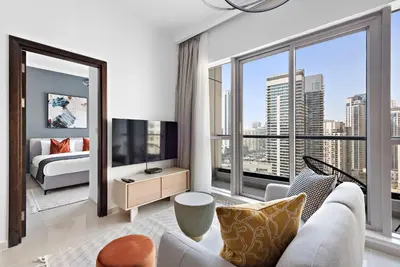 a living room with a couch and a large window at Silkhaus in Bay Central Near Metro in Dubai