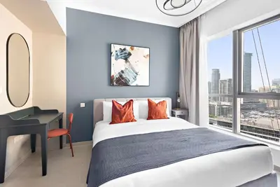 a bedroom with a bed and a desk and a window at Silkhaus in Bay Central Near Metro in Dubai