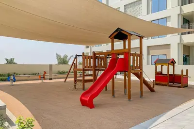 a playground with a red slide in a building at Frank Porter - Summer at Creek Beach in Dubai
