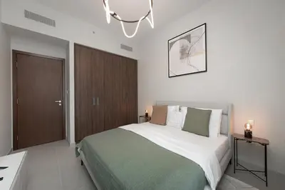 a bedroom with a large bed and a chandelier at Luxury apartments at Vida Residences in Dubai