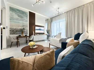 a living room with a couch and a table at Trophy - Santorini Studio BurjKhalifa & Canal Views Sofa Bed in Dubai