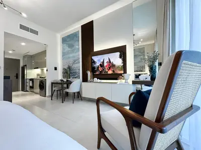 a bedroom with a bed and a living room and a kitchen at Trophy - Santorini Studio BurjKhalifa & Canal Views Sofa Bed in Dubai