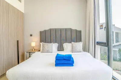 a bedroom with a large white bed with blue towels on it at New Arabian Dubai Hills villa- 3 BR & Maid Golf Grove With Private pool in Dubai