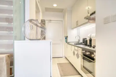 a kitchen with white cabinets and a large appliance at Studio in Palm Views West at Palm Jumeirah by PK Holidays in Dubai