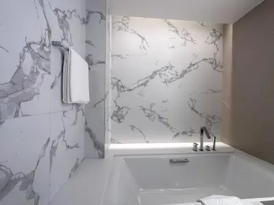 a bathroom with a tub and a marble wall at Address Residence Dubai Opera 21 by Luxstay Holiday Homes in Dubai