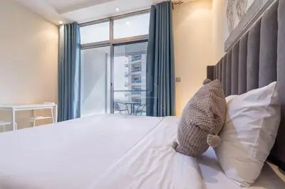 a teddy bear sitting on a bed in a bedroom at Very nice studio in Skyview Tower Dubai Marina in Dubai