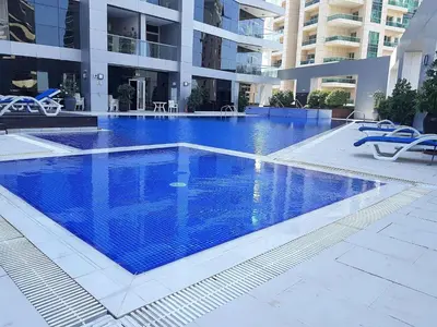 a large blue swimming pool in a building at Very nice studio in Skyview Tower Dubai Marina in Dubai